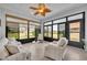 Bright sun room with tile floor, large windows overlooking backyard, and comfortable seating at 109 Falling Acorn Ave, Groveland, FL 34736