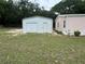 Exterior view of a metal garage with a roll-up door and separate entry alongside a home at 10905 Se 127Th Ln, Belleview, FL 34420