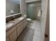 Bathroom featuring double sinks, granite countertops, and a walk-in shower at 1105 Hazelnut Dr, Leesburg, FL 34748