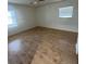 Bright bedroom with wood floors, two windows, and neutral walls, creating a blank canvas for personalization at 1105 Hazelnut Dr, Leesburg, FL 34748