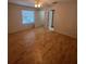 Bedroom with hardwood flooring, ceiling fan, and a view into an ensuite bathroom at 1105 Hazelnut Dr, Leesburg, FL 34748