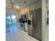 Well-lit kitchen featuring stainless steel appliances and access to the screened-in lanai at 1105 Hazelnut Dr, Leesburg, FL 34748