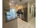 Spacious kitchen equipped with stainless steel appliances, tile flooring, and a view to the outdoor lanai at 1105 Hazelnut Dr, Leesburg, FL 34748