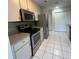 Kitchen with stainless appliances, light wood cabinets and tile flooring at 1105 Hazelnut Dr, Leesburg, FL 34748