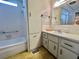 Bathroom featuring a bathtub, sink with vanity, and a tall storage cabinet offering lots of storage space at 112 Caladium St, Leesburg, FL 34748