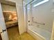 Bathroom showcasing the shower-tub combo next to the open bedroom, with grab bars for accessibility at 112 Caladium St, Leesburg, FL 34748