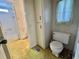 Bathroom view with a toilet and a storage cabinet featuring white paneling and an adjacent bathtub at 112 Caladium St, Leesburg, FL 34748