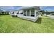 A view of a single story home with pristine lawn, white siding and brick skirting at 112 Caladium St, Leesburg, FL 34748