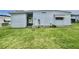 Side view of single story home with pristine lawn, white siding and brick skirting at 112 Caladium St, Leesburg, FL 34748