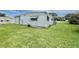 Side view of single story home with pristine lawn, white siding and brick skirting at 112 Caladium St, Leesburg, FL 34748