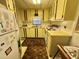 A cozy kitchen shows yellow cabinetry, white appliances, and wood flooring at 112 Caladium St, Leesburg, FL 34748