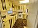 Compact kitchen features yellow cabinets, a white stove, and a double sink beneath a window at 112 Caladium St, Leesburg, FL 34748