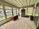 Enclosed sunroom with multiple windows, light neutral carpet, and casual seating furniture at 112 Caladium St, Leesburg, FL 34748