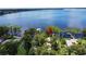 Waterfront property with private dock and covered boat lift, surrounded by lush trees and serene water views at 11401 Cypress Dr, Clermont, FL 34711