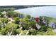 Scenic aerial view showcasing a waterfront property with a private dock, surrounded by trees and tranquil lake waters at 11401 Cypress Dr, Clermont, FL 34711