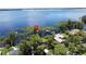 Lakeside home featuring a private dock with a covered boat lift, surrounded by lush greenery and serene water views at 11401 Cypress Dr, Clermont, FL 34711