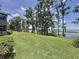 Expansive backyard with mature trees, lush greenery, and a serene view of the lake and private dock at 11401 Cypress Dr, Clermont, FL 34711