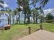 Lush backyard with mature trees, a small wooden dock, and a well-maintained lawn at 11401 Cypress Dr, Clermont, FL 34711