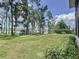Spacious backyard with a manicured lawn, mature trees, and access to the waterfront at 11401 Cypress Dr, Clermont, FL 34711