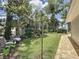 View of the backyard featuring a lush lawn, mature trees, a clothesline, and a brick walkway at 11401 Cypress Dr, Clermont, FL 34711