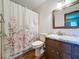 Bathroom featuring a marble countertop vanity and a shower with a decorative floral shower curtain at 11401 Cypress Dr, Clermont, FL 34711