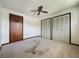 This bedroom features neutral walls, a ceiling fan, and closet doors at 11401 Cypress Dr, Clermont, FL 34711