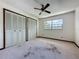 Bedroom with double closets, ceiling fan and natural light from the window at 11401 Cypress Dr, Clermont, FL 34711