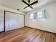 Bright bedroom with hardwood floors, a ceiling fan, a closet, and natural light from the windows at 11401 Cypress Dr, Clermont, FL 34711