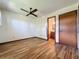 Bright bedroom with hardwood floors, ceiling fan, doorways to bathroom and hall, and closet at 11401 Cypress Dr, Clermont, FL 34711