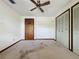 This bedroom features neutral walls, a ceiling fan, and closet doors at 11401 Cypress Dr, Clermont, FL 34711