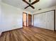 Bright bedroom with hardwood floors, ceiling fan, closet, and views to the adjoining bathroom at 11401 Cypress Dr, Clermont, FL 34711