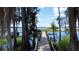 Scenic view of a private wooden dock leading to a serene lake, fringed by trees and aquatic vegetation at 11401 Cypress Dr, Clermont, FL 34711