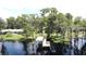 Aerial view showcasing a private dock with a covered boat lift, nestled on a tranquil lake surrounded by trees at 11401 Cypress Dr, Clermont, FL 34711