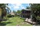 Exterior of the home with large windows, nice lawn, and wooden deck at 11401 Cypress Dr, Clermont, FL 34711
