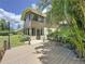Exterior view of home from the backyard featuring the upper level sunroom and lower level entrance at 11401 Cypress Dr, Clermont, FL 34711