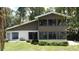 Exterior of home featuring multiple windows, a chimney, sliding doors, and lush landscaping at 11401 Cypress Dr, Clermont, FL 34711