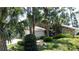 Landscaped house exterior with mature trees and greenery and a mix of stone and siding at 11401 Cypress Dr, Clermont, FL 34711