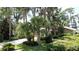 Exterior of landscaped house with palm trees, lush greenery, and a mix of stone and siding at 11401 Cypress Dr, Clermont, FL 34711