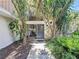 Home featuring a stone facade, large windows, and mature trees surrounding the entryway at 11401 Cypress Dr, Clermont, FL 34711