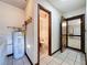 Hallway featuring tile floor, laundry hook-ups, hot water heater and access to bathroom and garage at 11401 Cypress Dr, Clermont, FL 34711