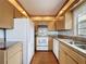 A well-lit kitchen with light wood cabinets, white appliances, and granite countertops at 11401 Cypress Dr, Clermont, FL 34711