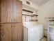 Spacious laundry room with overhead shelving, wooden cabinet, and storage space at 11401 Cypress Dr, Clermont, FL 34711