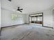 Spacious living room with large windows, a ceiling fan, and sliding glass doors to an enclosed patio at 11401 Cypress Dr, Clermont, FL 34711