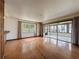 Open living room with hardwood floors, window, and access to an enclosed sunroom at 11401 Cypress Dr, Clermont, FL 34711