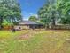 View of a large backyard with mature trees, patio and screened in porch at 12181 Se 87Th Ct, Belleview, FL 34420
