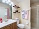 Bathroom featuring a vanity, toilet, glass-enclosed shower, and decorative shelves at 12181 Se 87Th Ct, Belleview, FL 34420