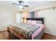 Comfortable bedroom with a ceiling fan, wood-look flooring, pink accents and an en suite bathroom at 12181 Se 87Th Ct, Belleview, FL 34420
