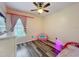Cozy bedroom with bright pink decor, laminate floor, window, and natural light at 12181 Se 87Th Ct, Belleview, FL 34420