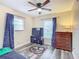 Small bedroom featuring a TV, laminate floor, dresser, and a large window at 12181 Se 87Th Ct, Belleview, FL 34420