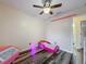 Bedroom with laminate floor and bright pink decor, including a bed and shelves at 12181 Se 87Th Ct, Belleview, FL 34420
